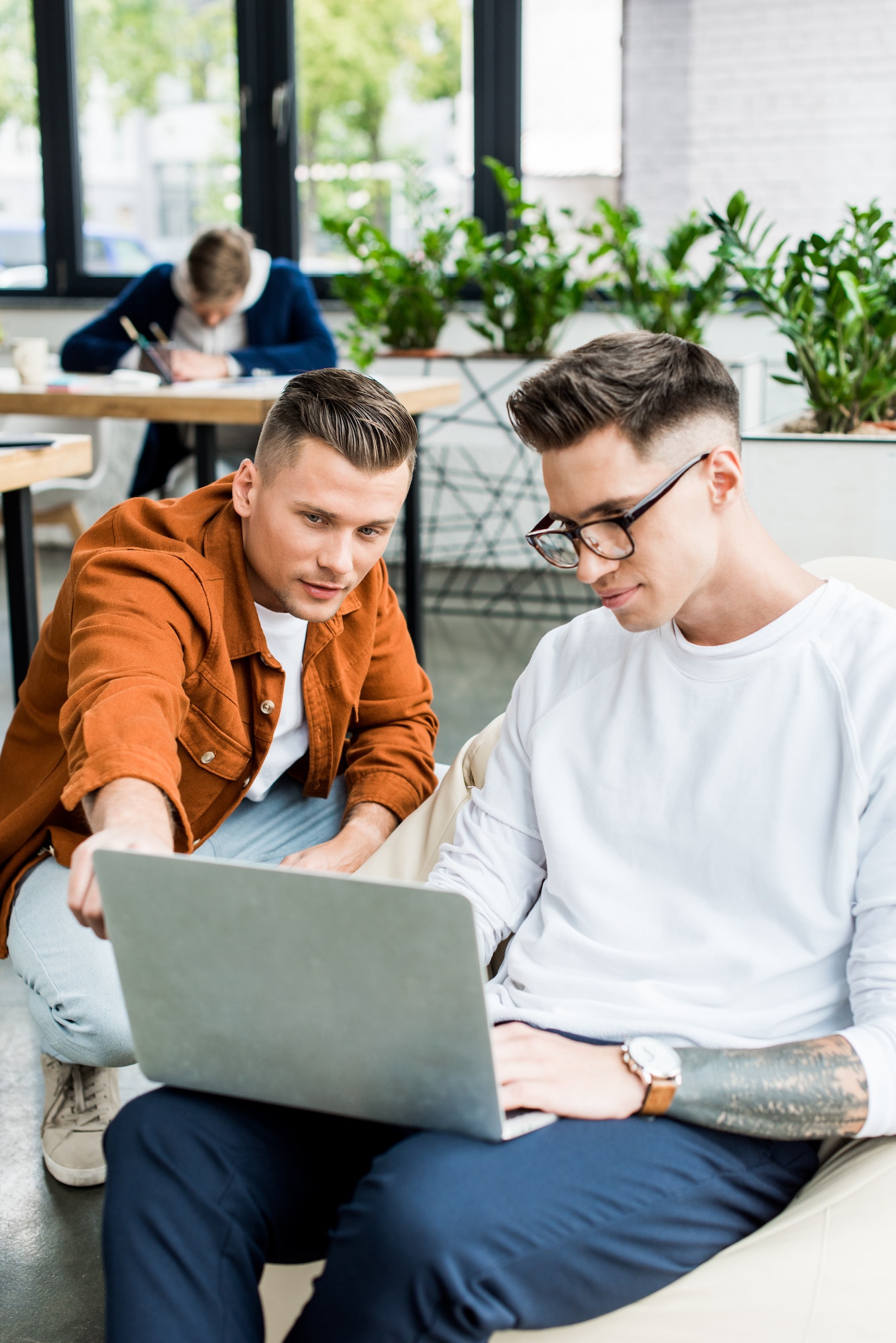 young businessmen looking at laptop while working on startup project together